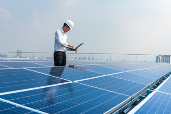 asian man on computer among solar panels
